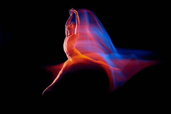 柔韧的男芭蕾舞蹈演员在明亮的艳丽霓虹灯下 在黑暗的背景下孤身一人地跳舞 思考舞蹈的概念 演员飞行 — 图库照片