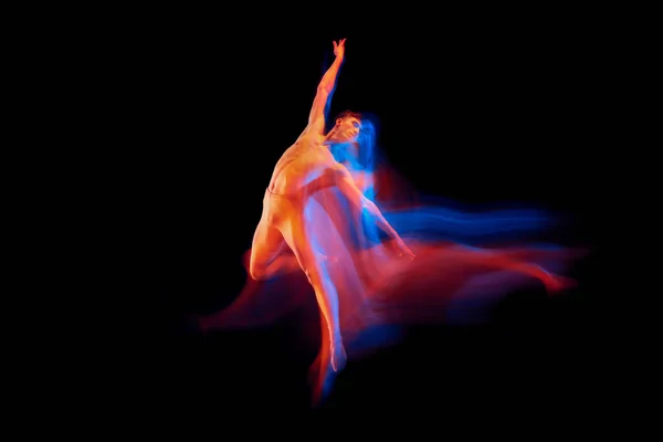 柔韧的男芭蕾舞蹈演员在明亮的艳丽霓虹灯下 在黑暗的背景下孤身一人地跳舞 思考舞蹈的概念 演员飞行 — 图库照片