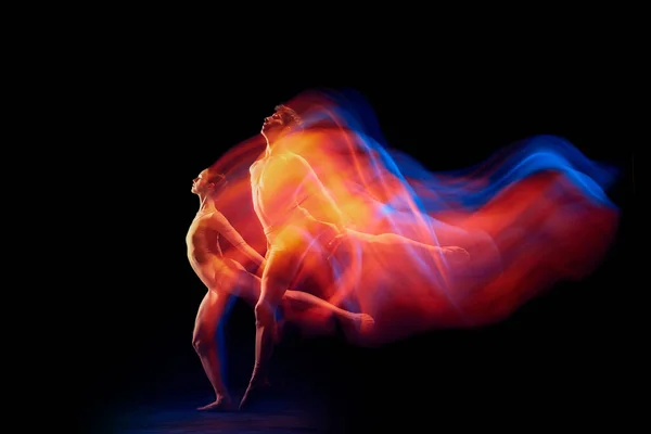 在混合的霓虹灯下 一对优雅而脆弱的芭蕾舞演员在行动中在黑色背景上被隔离 未来主义幻想奇迹艺术 灵活性 创造力和广告 — 图库照片