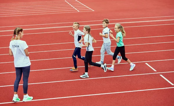 Kvinnliga Tränare Idrottare Grupp Barn Som Springer Löpband Arenan Begreppet — Stockfoto