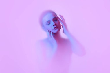 Duman bulutlarına gömülü genç kızın mistik portresi. Pembe neon arka planda sis ve arka plan difüzörü. Sanat kavramı, metaevren, teknoloji, sanal gerçeklik. Bulanık efekt