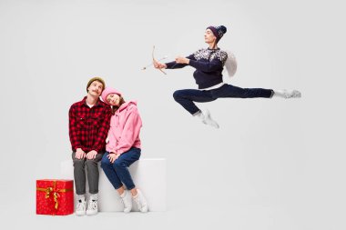 Romantizm ve aşık olmak. Gri arka planda birlikte vakit geçiren, kalın elbiseli balerinlerin yaratıcı portresi. Mutlu Noeller, yeni yıl, tatiller, parti konsepti. Kış modası