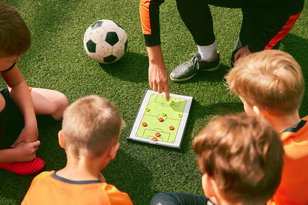 フットボールの練習だ サッカーコーチは タブレット 地図を使用してゲームのルールや戦略を説明する トレーナーと草のピッチに座っているスポーツジュニアチーム スポーツ スキルの概念 — ストック写真