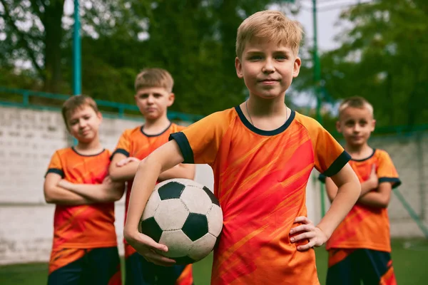 将来のサッカーチャンピオン 小さな男の子 サッカー学校のスタジアムでボールをポーズでスポーツ制服の子供たち スポーツ 成功とスキルの概念 幸せそうだ — ストック写真
