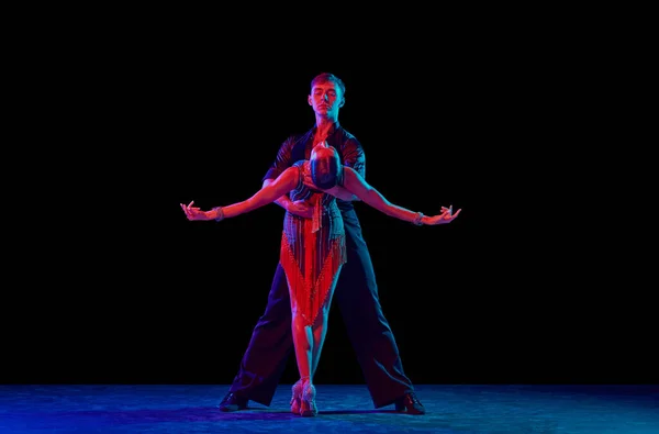 两个跳舞的人 穿着优雅的舞衣的舞女在运动 在霓虹灯的黑暗背景下表演 人类情感的概念 — 图库照片