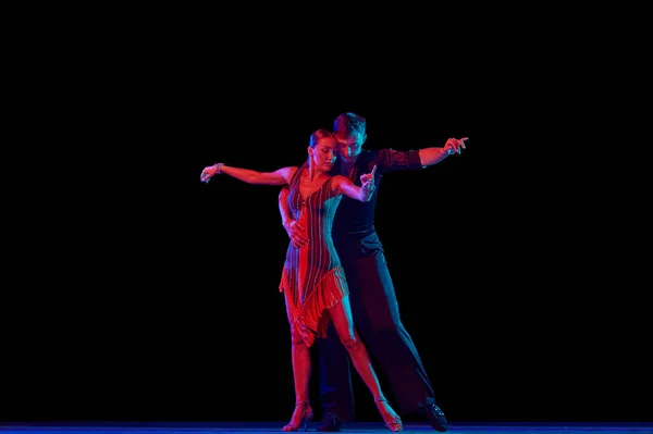 时尚的舞厅舞伴们穿着华丽的服装 在霓虹灯下 以性感的姿势在黑暗的背景下跳舞 人类情感的概念 — 图库照片