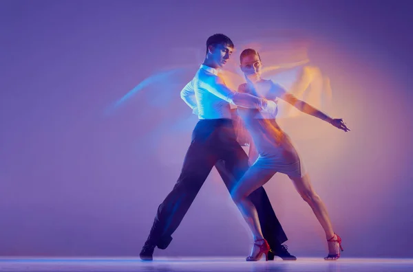迷人的 年轻优雅的舞蹈家 柔韧的男男女女 在霓虹灯的混合灯光下 用深蓝色紫色背景隔离着舞姿 美的概念 风格和广告 — 图库照片