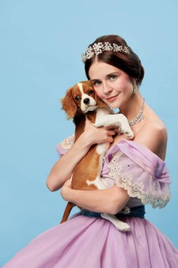 Sevgili hayvanım. Leylak renginde, asil bir insan gibi giyinmiş genç ve çekici bir kadının portresi. Mavi arka planda küçük Kral Charles Spaniel köpeğini tutan bir prenses. Güzellik, eski moda, duygular