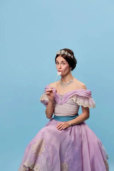 라일락 드레스를 관능적 소녀의 여왕이나 공주가 사탕을 맛보는 모습이다 바보같은 — 스톡 사진