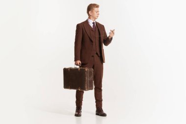 Genç bir adamın portresi, 50 'li yaşlarda takım elbiseli bir işadamı, 60' lı yılların moda tarzı beyaz arka planda izole edilmiş. Modern kültür, güzellik ve reklam kavramı. Döngüsel moda. İlan için alanı kopyala