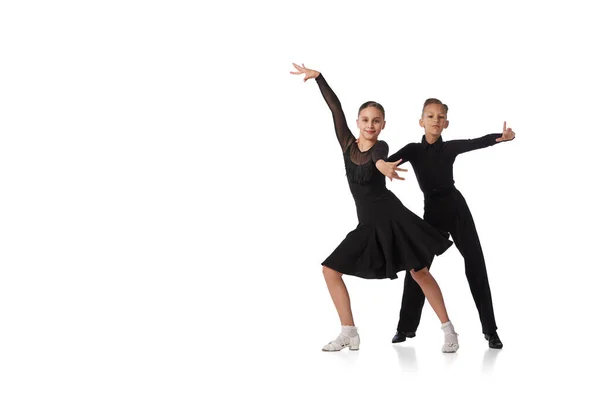 ダンスカップル 黒の舞台衣装を着た2人の子供 女子高生と少年が白い背景で孤立したダンスを踊る スポーツダンス 広告のスペースをコピーします 子供は見る — ストック写真