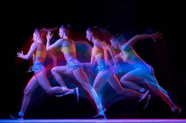 运动的发展 职业女运动员 在混合霓虹灯下在黑暗背景下跑步 穿着运动服的活泼姑娘在跑步或慢跑时练习 健康生活方式概念 — 图库照片