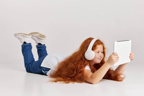 Rajzfilmeket Nézek Aranyos Vörös Hajú Kislány Pólót Farmert Visel Táblagéppel — Stock Fotó