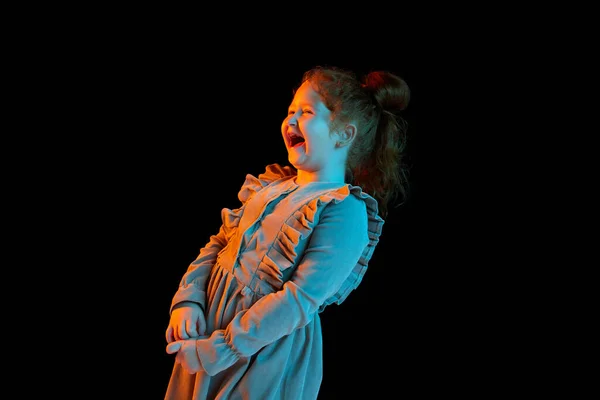 在霓虹灯下 身穿节日礼服的可爱而快乐的小女孩在深色背景下被隔离的半身画像 孩子的情感 面部表情 时尚的概念 快乐的童年 — 图库照片