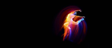 Mucize uçuşta. Beyaz elbiseli genç bir dansçı havada süzülüyor, karışık neon ışıkta karanlık arka planda hareket ediyor. Yaratıcı sanat, arzu, müzik, moda, dans. İlan için alanı kopyala