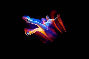 Yaratıcı dinamik atlet portresi, beyaz spor kıyafetleri içinde atlayan dansçı, karışık neon ışıkta karanlık arka planda uçan, ışıldayan. Sanat, arzu, müzik, moda. İlan için alanı kopyala