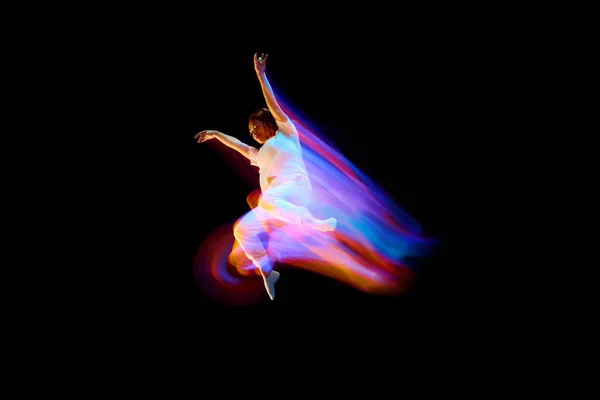 跳起舞来演播室拍摄的飞行 跳跃舞者或体操运动员表演技巧在黑色背景与混合霓虹灯光芒在空中 网络朋克 — 图库照片