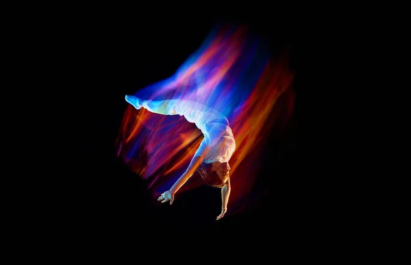 富有创意的动态的运动员肖像 穿着白色运动服的舞者跳跃着 在混合的霓虹灯下在黑暗的背景上飞翔 闪闪发光 广告的复制空间 — 图库照片