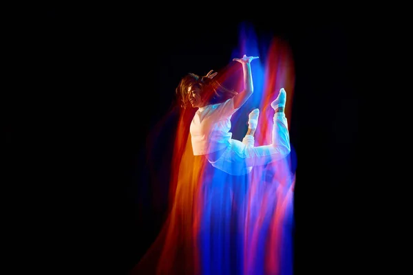 在神奇的飞行中穿着白色衣服的年轻的 活泼的舞蹈演员在混合的霓虹灯下在黑暗的背景上飘荡 创意艺术 广告的复制空间 — 图库照片