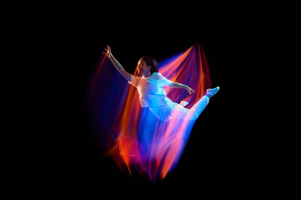 在神奇的飞行中穿着白色衣服的年轻的 活泼的舞蹈演员在混合的霓虹灯下在黑暗的背景上飘荡 创意艺术 广告的复制空间 — 图库照片