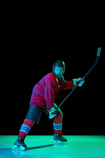 強力な投球 ネオンライトの暗い背景にアクションでスポーツ制服や保護機器の男性アイスホッケー選手 スポーツ パワー 目標概念 — ストック写真