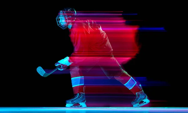 強力な投球 ネオン混合光の暗い背景の上にアクションでスポーツ保護制服の男性アイスホッケー選手 スポーツ パワー 目標概念 — ストック写真