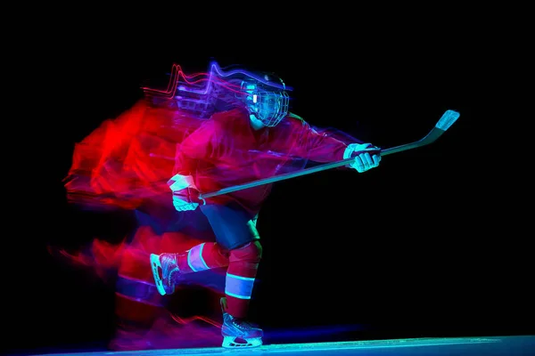 強力な投球 ネオン混合光の暗い背景の上にアクションでスポーツ保護制服の男性アイスホッケー選手 スポーツ パワー 目標概念 — ストック写真