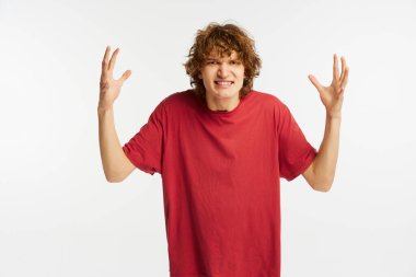 Sinirli görünüyor. Öfkeli genç çocuk beyaz arka planda izole edilmiş öfkeyle ellerini kaldırıyor. Ruh sağlığı kavramı, saldırganlık, duygular, gençlik, reklam