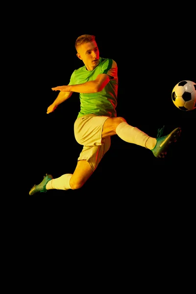 踢足球 在霓虹灯下 年轻活跃的足球运动员在黑暗背景下被隔离的动态镜头 体育概念 业余爱好 — 图库照片