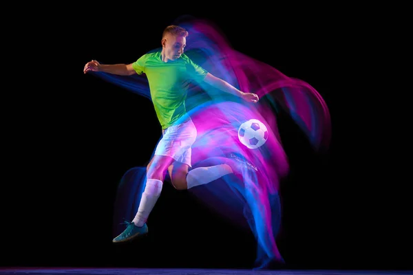 流口水了年轻的足球运动员 运动中的足球运动员和行动与球隔离在黑暗的背景在霓虹灯混合光 能量的概念 文字的复制空间 — 图库照片