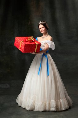 Noel hediyesi. Genç kraliçe. Rönesans tarzı giyinmiş ortaçağ kraliyet insanı portresi. Karanlık arka planda izole edilmiş. Dönem, güzellik, tarih, sanat, tarih karşılaştırması