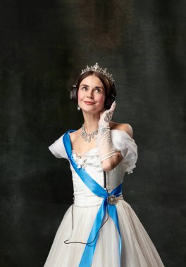 En sevdiği müzik. Zarif kadın, kraliyet mensubu, kulaklıklı kraliçe ya da prenses ve klasik arka plandaki ortaçağ müziği. Çağlar, modern tatlılar, moda, güzellik karşılaştırması kavramı