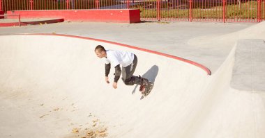 Modern paten parkında patenli enerjik bir adam hareket halinde. Profesyonel patenci tehlikeli ve cüretkar numaralar yapıyor. Spor, sağlık, hız ve enerji kavramı. Boş zaman.