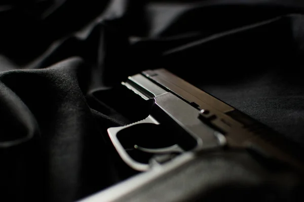Schwarze Handfeuerwaffe Seitenarm Auf Schwarzem Stoffhintergrund Nahaufnahme Zurückhaltende Fotografie — Stockfoto