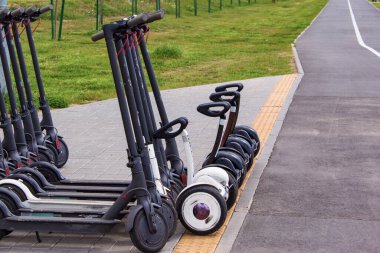 Elektrikli jiroskoplar ve arka arkaya park etmiş birkaç siyah elektrikli scooter..