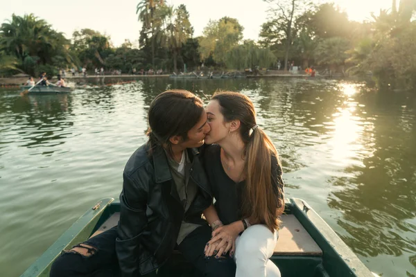 若いです男の子接吻彼のガールフレンドオンザ唇でAロマンチックなボートに乗る中日没 — ストック写真