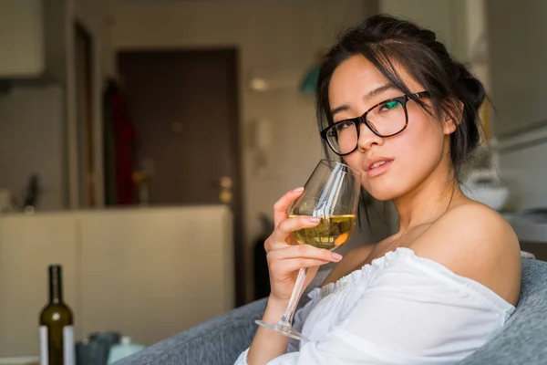 Interesting young chinese drinking wine and wearing glasses
