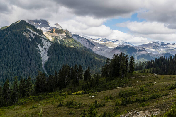 Beautiful view on Elfin Lakes hike in Garibaldi National Park, British Columbia, Canada. View of mountains, glaciers and moody, cloudy sky.