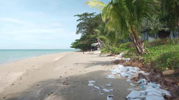 Playa de arena blanca con agua azul y cielo con contaminación plásica — Vídeos de Stock