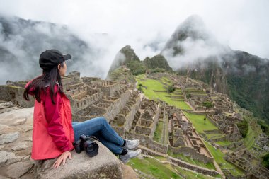 Peru 'nun Cusco bölgesindeki yedi harikadan biri olan Machu Picchu' ya bakan genç Asyalı kadın gezgin. Bu görkemli yer 