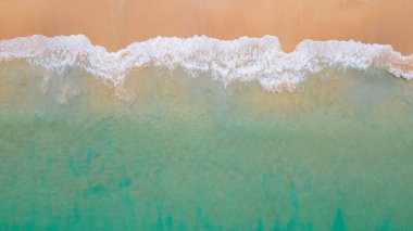 Kıyı şeridine ulaşan turkuaz okyanus dalgasının havadan görüntüsü. Üst manzaradan güzel tropikal plaj. Tayland 'da Andaman Denizi. Yaz tatili konsepti