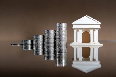 Bankacılık kavramı. Banka hesap faizi artışı. Parlak masa üzerine para istiflenmiş banka modeli.