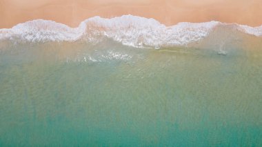 Kıyı şeridine ulaşan turkuaz okyanus dalgasının havadan görüntüsü. Üst manzaradan güzel tropikal plaj. Tayland 'da Andaman Denizi. Yaz tatili konsepti