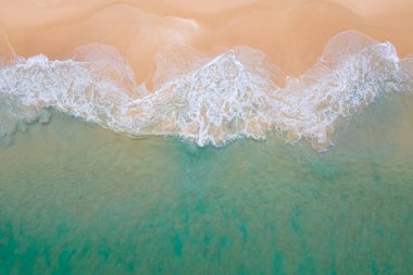 Kıyı şeridine ulaşan turkuaz okyanus dalgasının havadan görüntüsü. Üst manzaradan güzel tropikal plaj. Tayland 'da Andaman Denizi. Yaz tatili konsepti