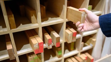 Erkek el fabrikadaki ahşap raftan kereste seçiyor. Ahşap endüstrisi