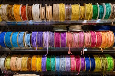Esnaf atölyesinde renkli bükülmüş kordon kurdelesi. Zanaatkar ve el işi malzemesi. DIY hobi konsepti