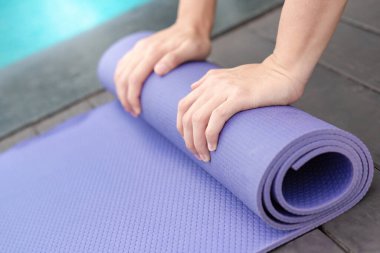Yüzme havuzunda el yapımı mor yoga minderi. Açık hava egzersizi ve sağlıklı yaşam tarzı konsepti
