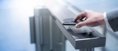 İş adamı eli, ofis binasındaki otomatik kapı makinesini açmak için akıllı telefon kullanıyor. Çalışma rutini kavramı