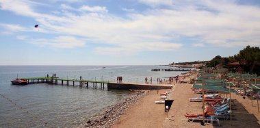 Türkiye 'de plaj, kumsalda güneşlenen turistler. Denizde iskele.