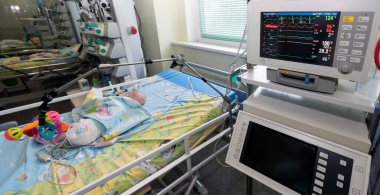 Arka plan bulanık. Yenidoğan Yoğun Bakım Ünitesi. Yenidoğan yoğun bakımında Yeni doğan çocuk, NICU 'daki yapay hayati aktivite cihazlarına bağlı.